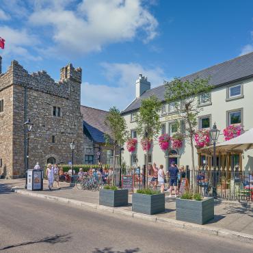 photograph taken from the road showing Dalkey Castle to the left of the frame, with the Queen's Pub to the right. 