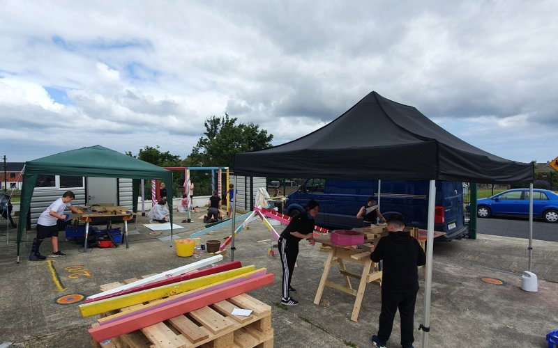 Image of young people building structure for outdoors