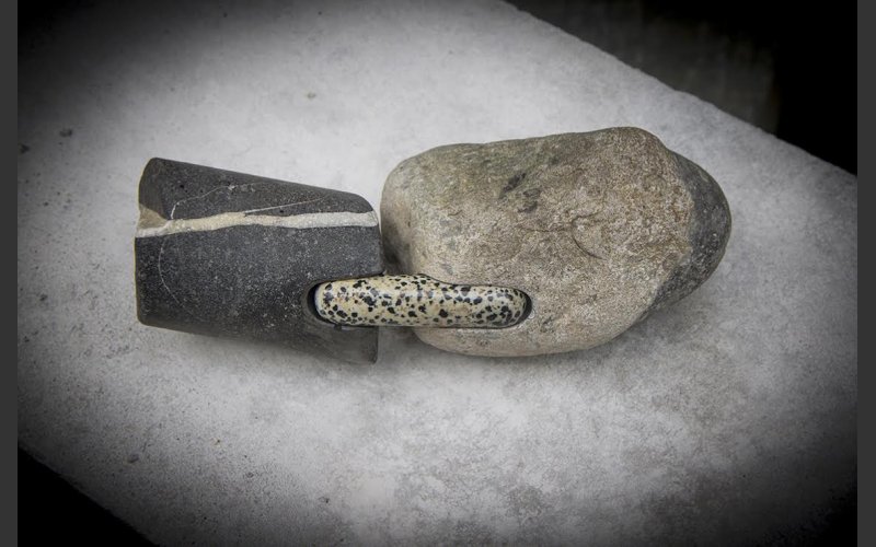 picture of a small stone sculpture. two rocks connected by a smaller rock
