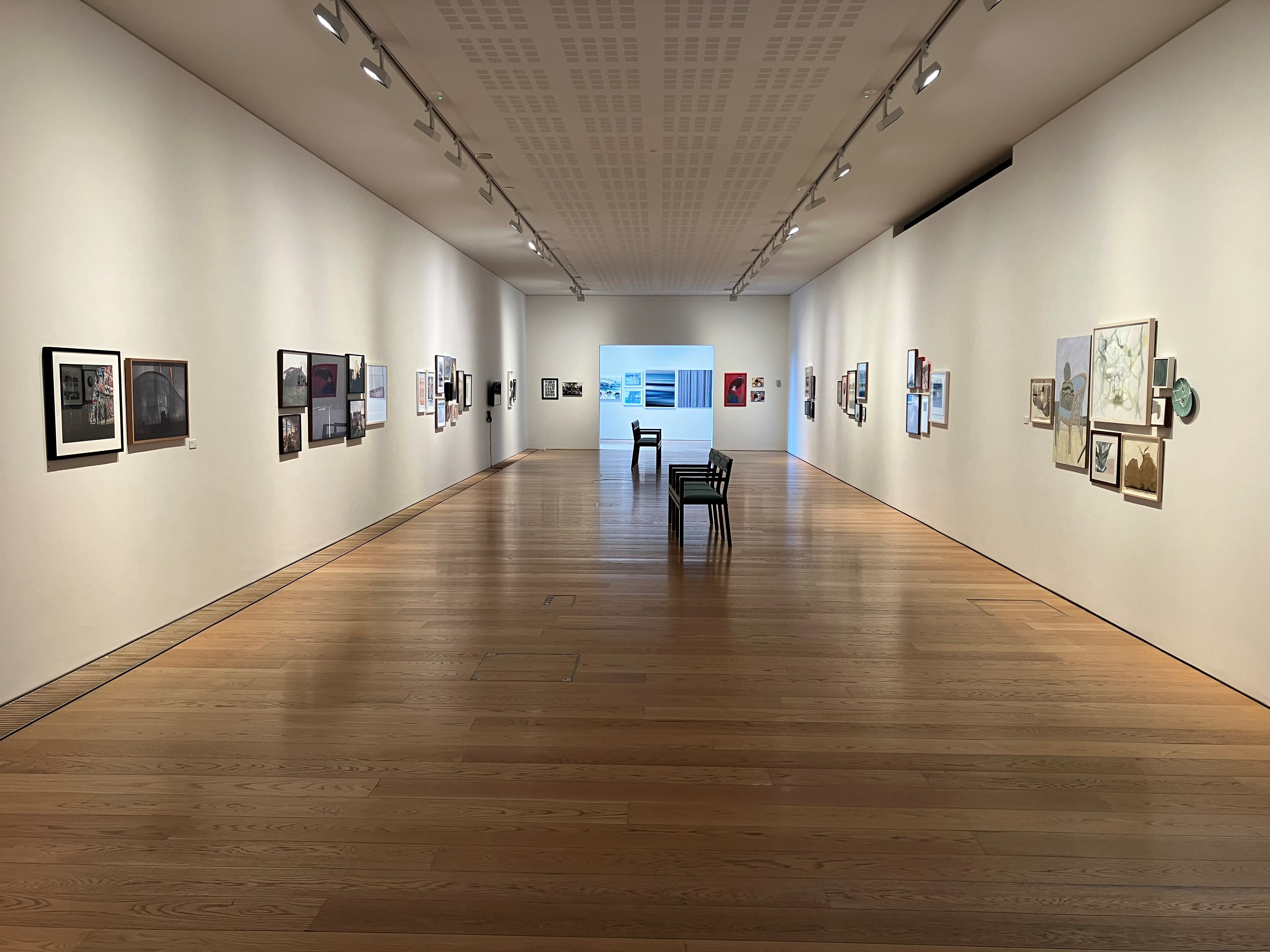 the municipal gallery in the lexicon library. Art work is clustered on the walls.