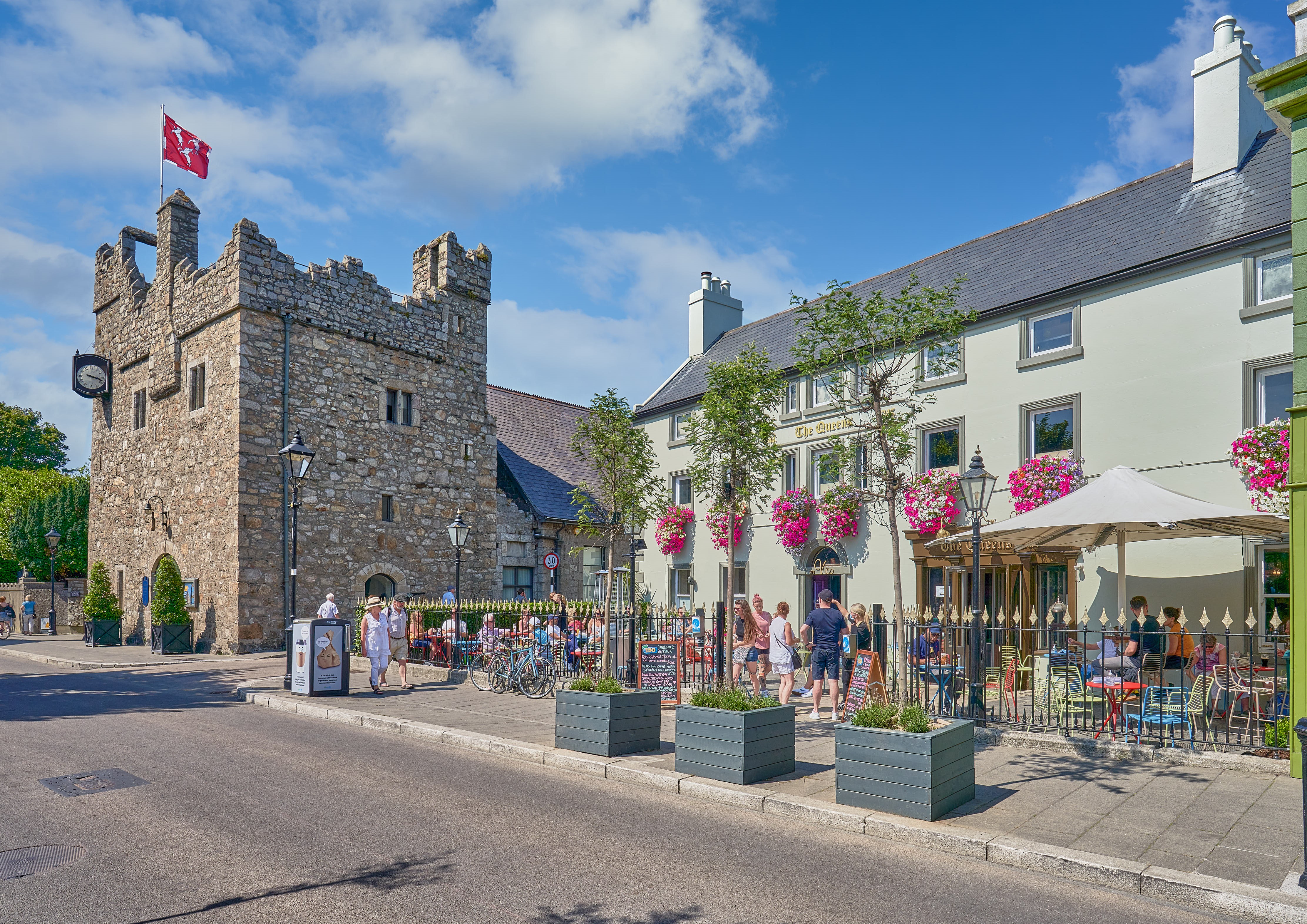photograph taken from the road showing Dalkey Castle to the left of the frame, with the Queen's Pub to the right.