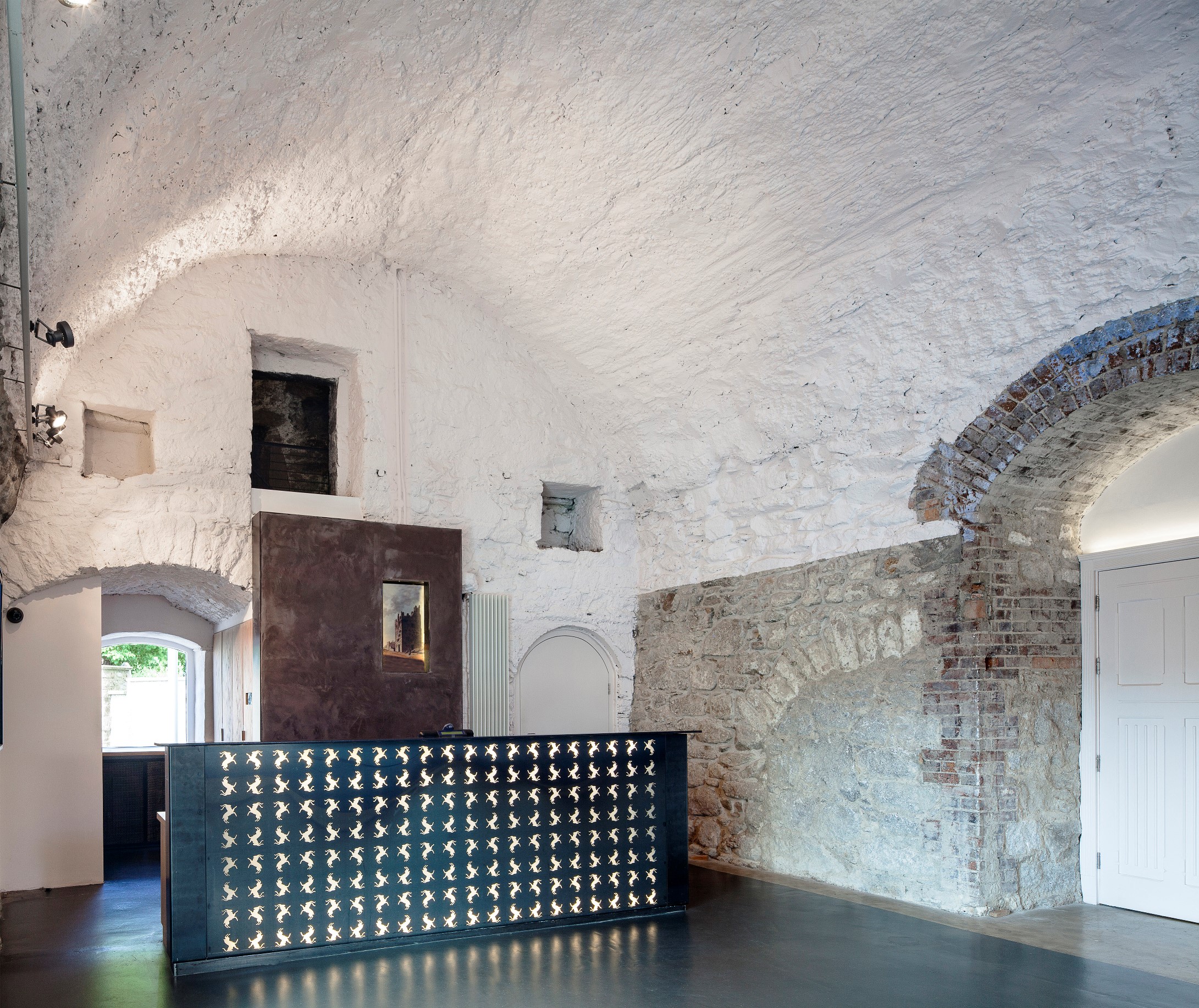 photograph showing layers of stone in the foyer of Dalkey Castle. some is exposed stone and other parts, including the barrel vaulted ceiling, is painted white