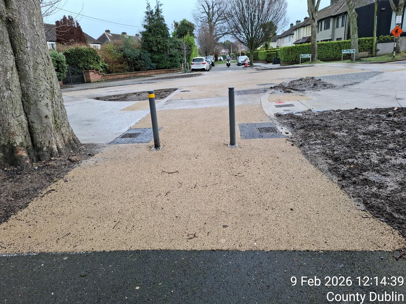 Paved walkway with two poles in the center, providing guidance and support for pedestrians.