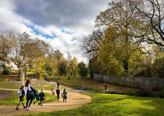 children and adult walking on apathway in a park 