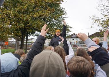 group of people raising hand in a park gathering 