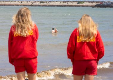 A photo of two lifeguards on duty looking out at the sea