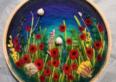 A piece of felt art depicting a field of poppies