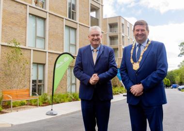 two men standing in front of apartment block