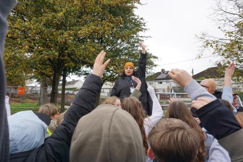 group of people raising hand in a park gathering 