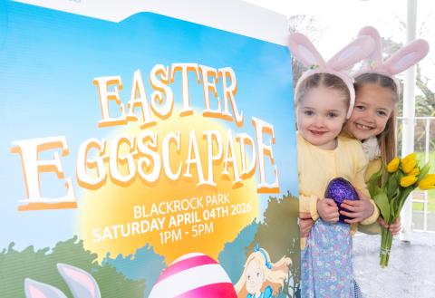 Two girls in front of Easter Eggscapade sign