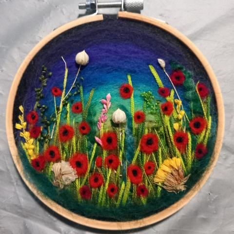 A piece of felt art depicting a field of poppies