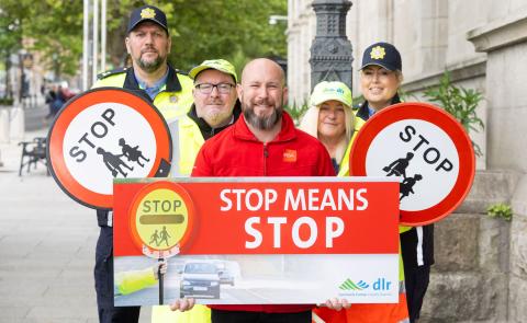 Gardai and school wardens from Dun Laoghaire hold up signs saying 'stop means stop' outside County Hall in Dun Laoghaire