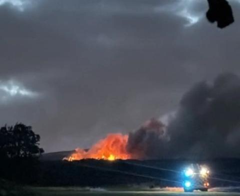 Fire and dark sky with fire truck in foreground