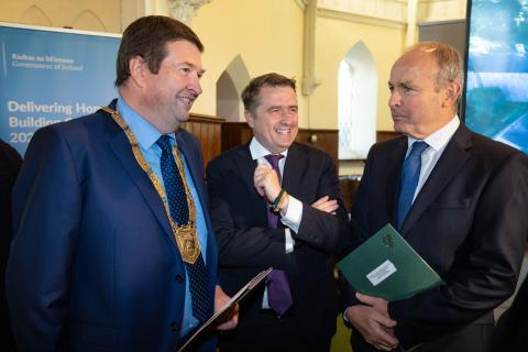 An Cathaoirleach Cllr Barry Saul, Minister for Housing, Local Government and Heritage, James Browne TD and An Taoiseach, Michael Martin taling in old church 