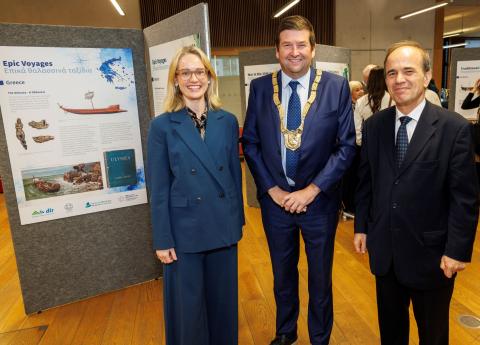 Ms Ciara O'Floinn, Ambassador of Ireland to Greece, Cllr Barry Saul, An Cathaoirleach of Dún Laoghaire-Rathdown County Council, Mr Georgius Stilianopoulos, Ambassador of Greece to Ireland standing next to information post 