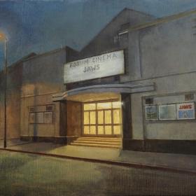 painting of the front of the old Forum cinema in Dún Laoghaire. The angle is a slight side view showing the main entrance at twilight, with light spilling onto the street from the cinema foyer. It is a warm yellow light and there is a streetlamp to the left hand side of the building too. The colour palette is soft with greys for the building and blue/purple sky.