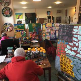 Artists in their studios in KCAT Studios, Kilkenny. Colourful canvases with two artists with their backs to the camera.
