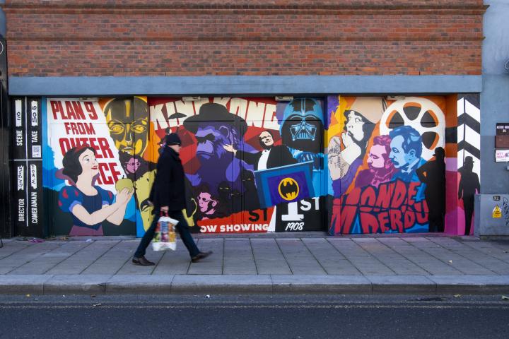 Person walking past Street Art with cinema theme