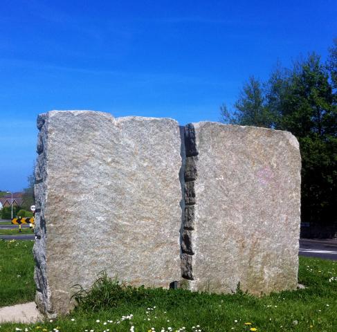 Stone sculpture. a large standing piece of granite with a gap down the middle