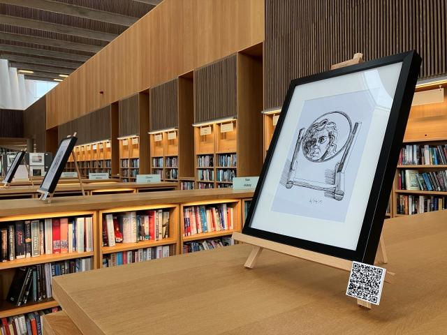 4 framed self portraits on bookshelves in the Lexicon Library