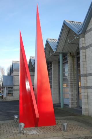 Abstract red metal sculpture. two large pointed triangles