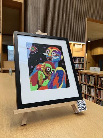 A colourful framed artwork sit on top of 3 wooden chest height bookcases in the Lexicon Library