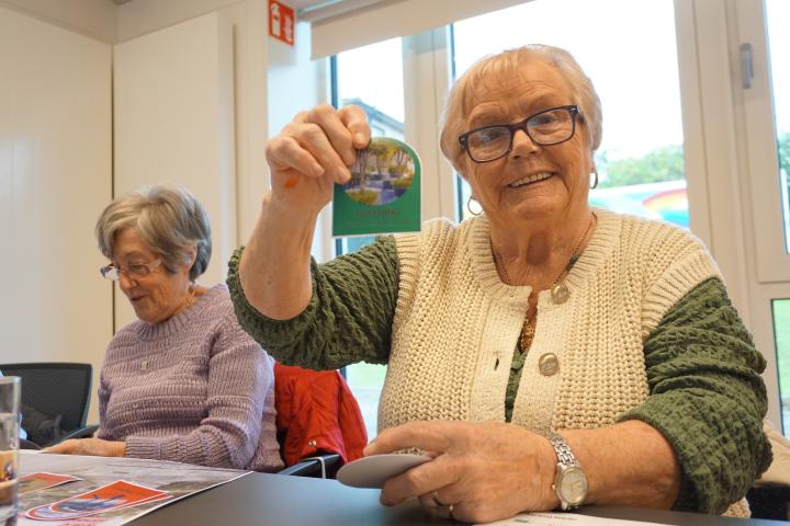 two elderly ladies sitting together &amp; one of them is shwoing a piece of the project enaggement map to the camera