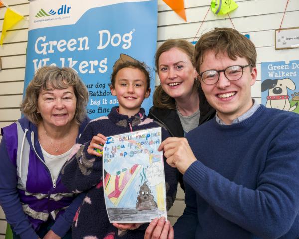 young girl, two female adults and one male with poster