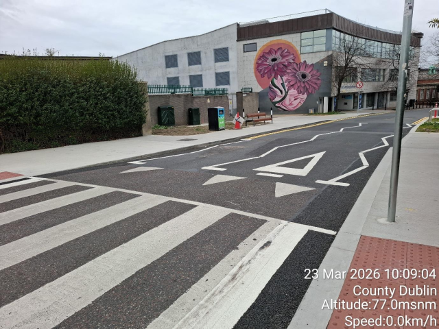 Street with crosswalk and building in background.