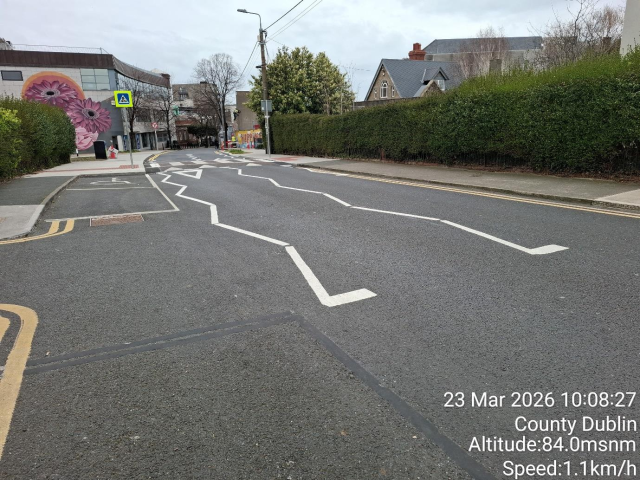A street with white lines painted on the pavement, indicating traffic lanes.
