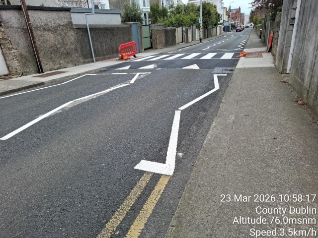 A street with white lines painted on the pavement, indicating traffic lanes.