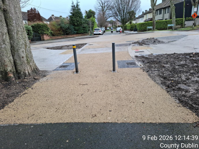 Paved walkway with two poles in the center, providing guidance and support for pedestrians.