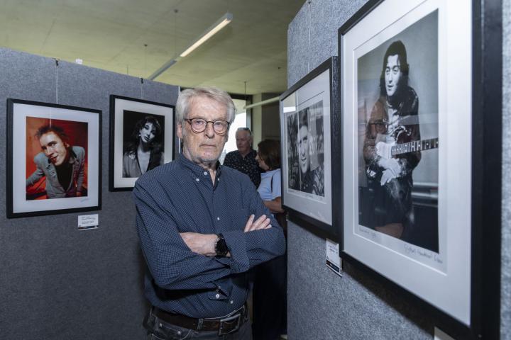 Gijsbert Hanekroot stands with his photo of Gilbert O'Sullivan playing guitar.