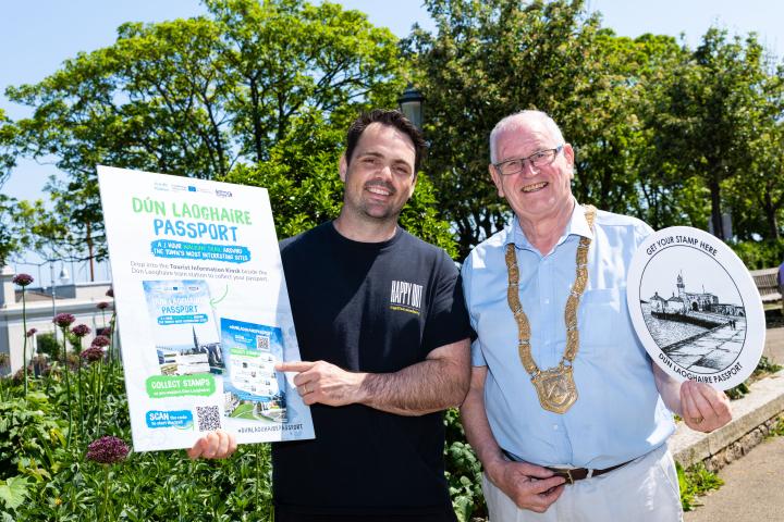Brian Hanratty, owner of Happy Out Cafés and An Cathaoirleach, Councillor Jim Gildea DLR holding up plagues advertising the Dun Laoghaire passport
