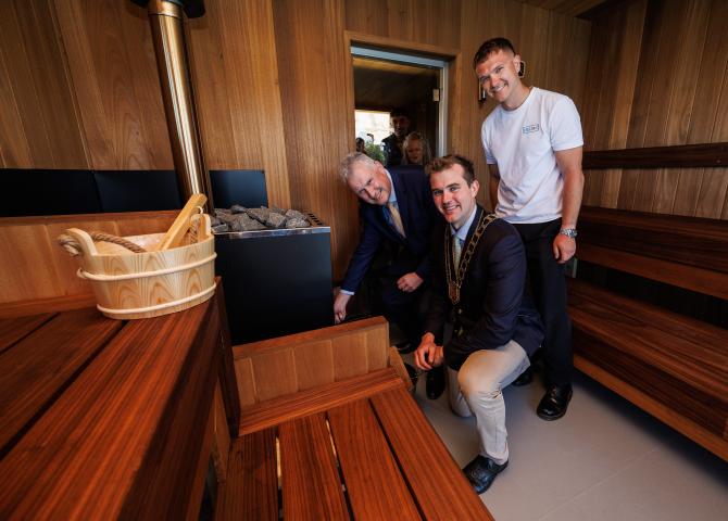 three men in front of sauna fire