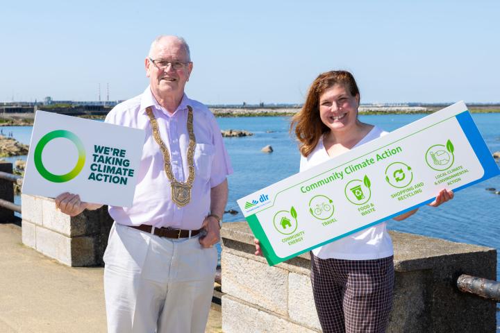 Cllr Jim Gildea, Cathaoirleach of Dún Laoghaire-Rathdown County Council with Cynthia O’Mahony Community Climate Action Officer standing at the Dun Laoghaire Baths holding a plaque.