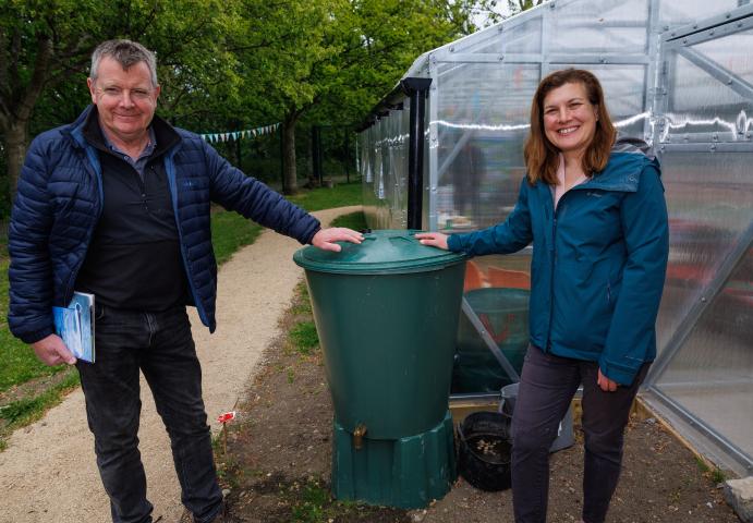 two people standing beside a water contrainer