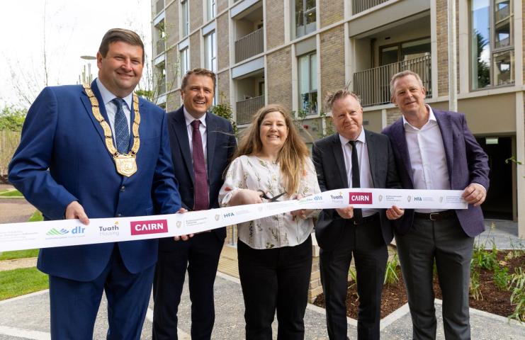 four men and one woman cutting a ribbon