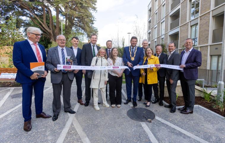 group of men and women cutting a ribbon
