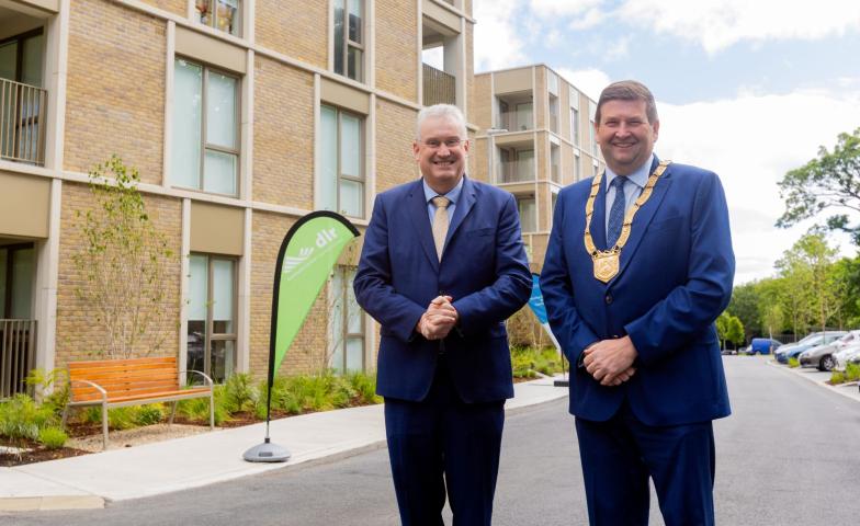 two men standing in front of apartment block