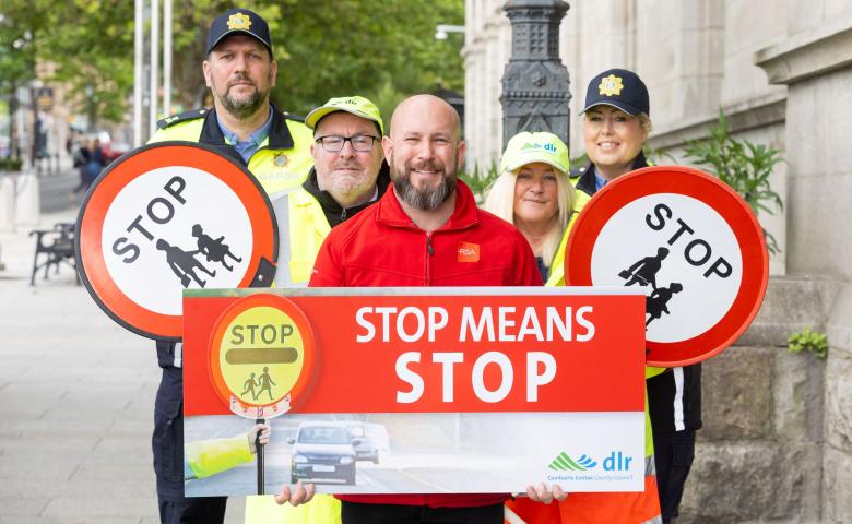 Gardai and school wardens from Dun Laoghaire hold up signs saying 'stop means stop' outside County Hall in Dun Laoghaire