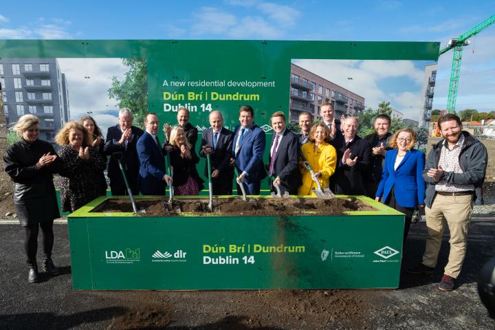 Group shot Cllr Lauren Tuite; Cllr Fiona Murray; Cllr Eva Dowling; Frank Curran – Chief Executive; Minister of State for Planning and Local Government, John Cummins TD; Cllr Anna Grainger; Cllr John Hurley; An Taoiseach, Michael Martin; An Cathaoirleach Cllr Barry Saul; Minister for Housing, Local Government and Heritage, James Browne TD; Cllr Tom Murphy; Maeve O'Connell TD; John Coleman – CE LDA; Shay Brennan TD; Cllr Oisin O’Connor; Cllr Martha Fanning and Peter O’Brien. on the grounds of constrction site