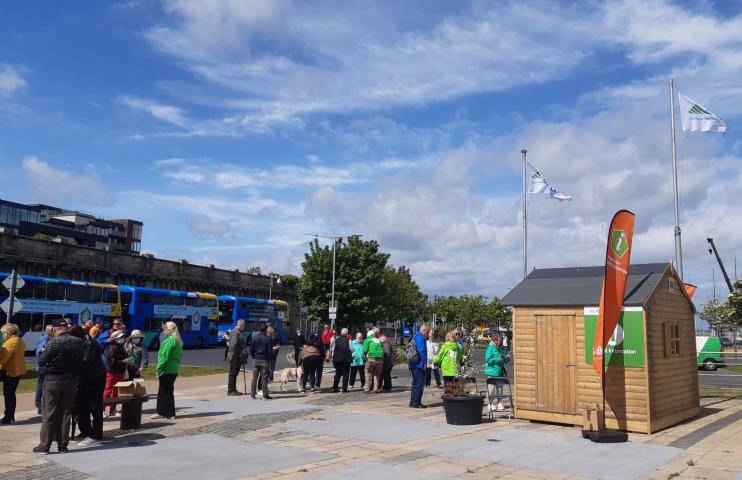 Cruise Welcome area with people waiting and the kiosk on a sunny day with blue sky