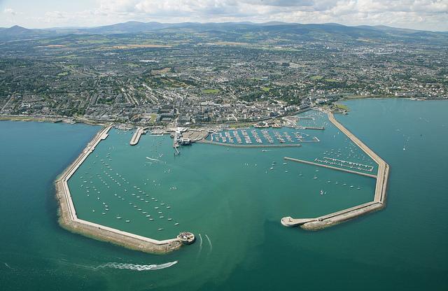 Arial shot of the full Dun Laoghaire Harbour with both piers and the hills and town in the background