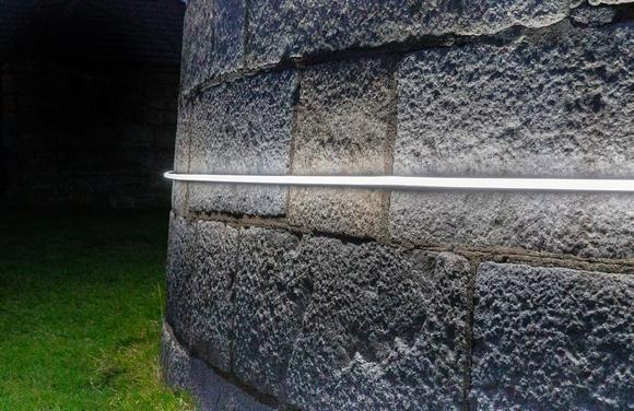 a close up night time shot of Martello Tower wrapped with solar powered ‘line of light’